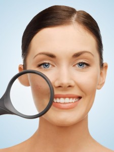 woman with magnifying glass over acne